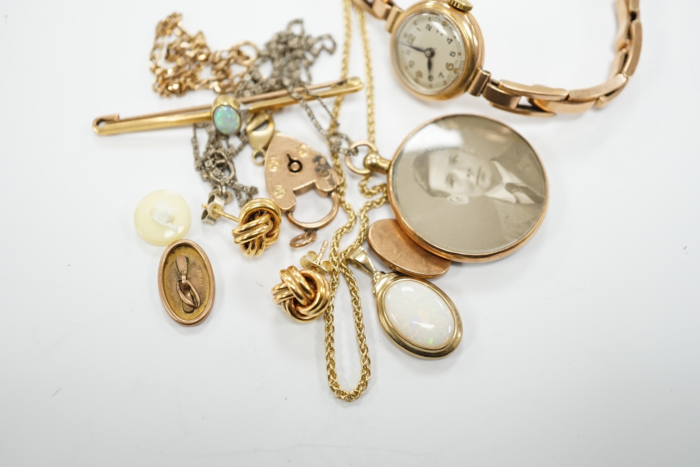 A lady's yellow metal manual wind wrist watch, on a 9ct expanding bracelet, a modern 9ct gold and white opal set pendant, on a 375 chain and other minor jewellery including a pair of 9ct gold knot earrings.